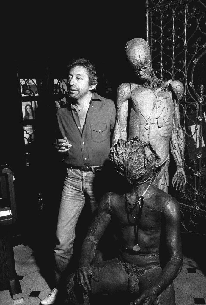 Serge Gainsbourg chez lui a cote de l'homme a la tete de chou de Claude Lalanne le 15 Avril 1982.