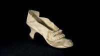 This handout picture taken on October 5, 2020 and released on November 13, 2020 by the Osenat Auction House in Versailles, west of the French capital Paris, shows a white shoe that once belonged to France's Queen Marie-Antoinette, fashioned from goatskin and silk with a leather sole and four overlapping pleated ribbons, and which measures 22.5 centimeters (8.8 inches) with a heel that is 4.7 centimeters (1.85 inches) in height. - The single shoe will be auctioned by Osenat in Versailles on November 15, 2020.  Belonging to Marie Antoinette, the last Queen of France who was executed during the French Revolution 1793, the shoe has a reserve of 8,000 to 10,000 ($9,450 to $11,800). The shoe had ended up with Marie-Emilie Leschevin, a close friend of the queen's head chambermaid, whose husband also died at the guillotine. The shoe had then stayed in subsequent generations of Leschevin's family. (Photo by - / OSENAT / AFP) / RESTRICTED TO EDITORIAL USE - MANDATORY CREDIT "AFP PHOTO / OSENAT / - "- NO MARKETING - NO ADVERTISING CAMPAIGNS - DISTRIBUTED AS A SERVICE TO CLIENTS