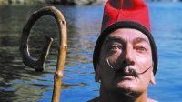 Cap Creus, 1955. Dalí au bain coiffé de la barretine catalane, tenant un bâton de pâtre.