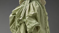 Anonyme, Robe de dessus (Nom d'usage), 1770, QTOV 1996 : taffetas de soie, passementerie de soie, bordure des manches gaze masse façonné soie, dentelle en soie, bourrage du volant en fibre végétale [ ? ] / PGB : soie taffetas chaîne vert, trame vert, doublure lin toile écrue, gaze [ ? ] soie blanche, passementerie / LRMH : rembourrage du volant : bourre de coton brut, baleines, se fermait par des oeillets et des liens. Palais Galliera, musée de la Mode de la Ville de Paris.