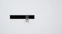 une_serge-najjar-a-l-instant-t-lahumiere Hyphen de Serge Najjar, homme assis dans une fente noire d'un mur blanc