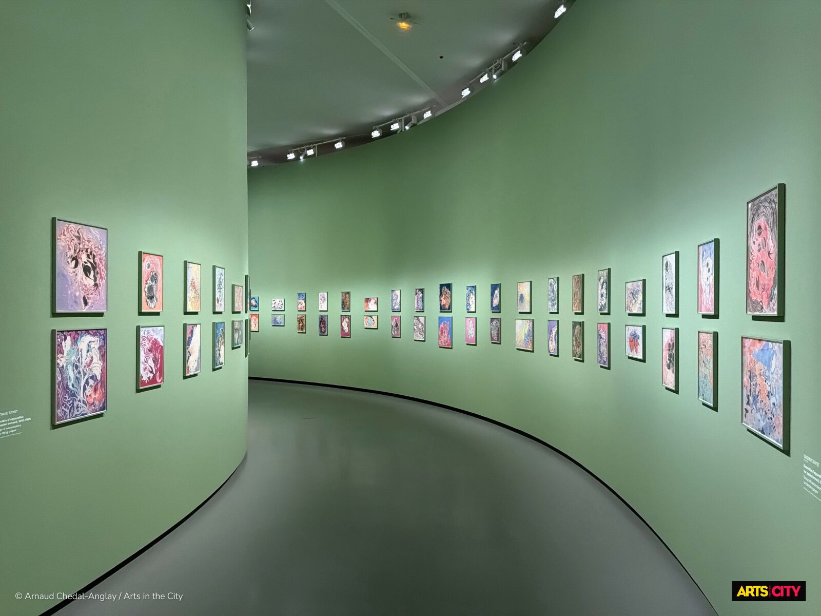 Galerie courbe aux murs verts présentant les aquarelles sur papier buvard de Gustave Fayet, exposition Gustave Fayet à la Fondation Louis Vuitton