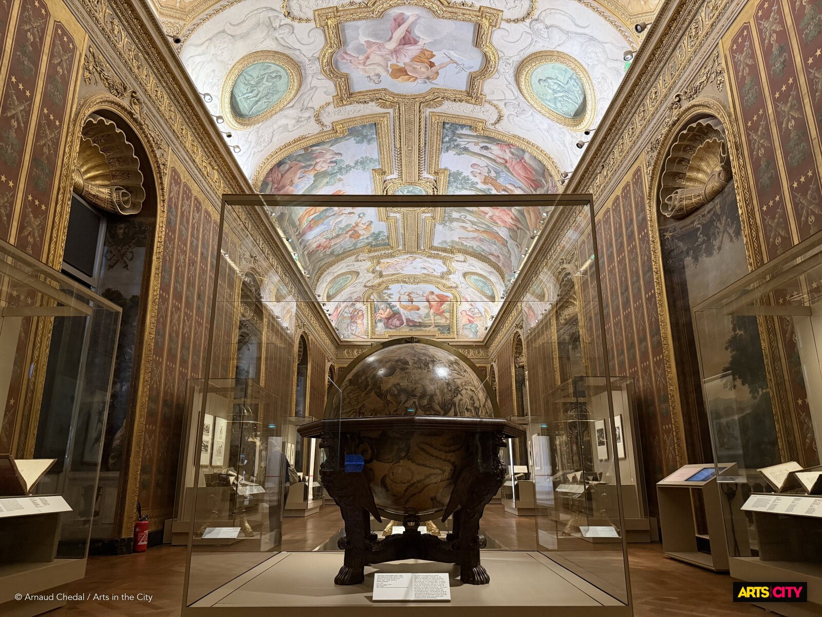 Un grand globe ancien sous le plafond peint de la galerie Mazarin, dans l’exposition Histoires d’animaux à la BnF Richelieu