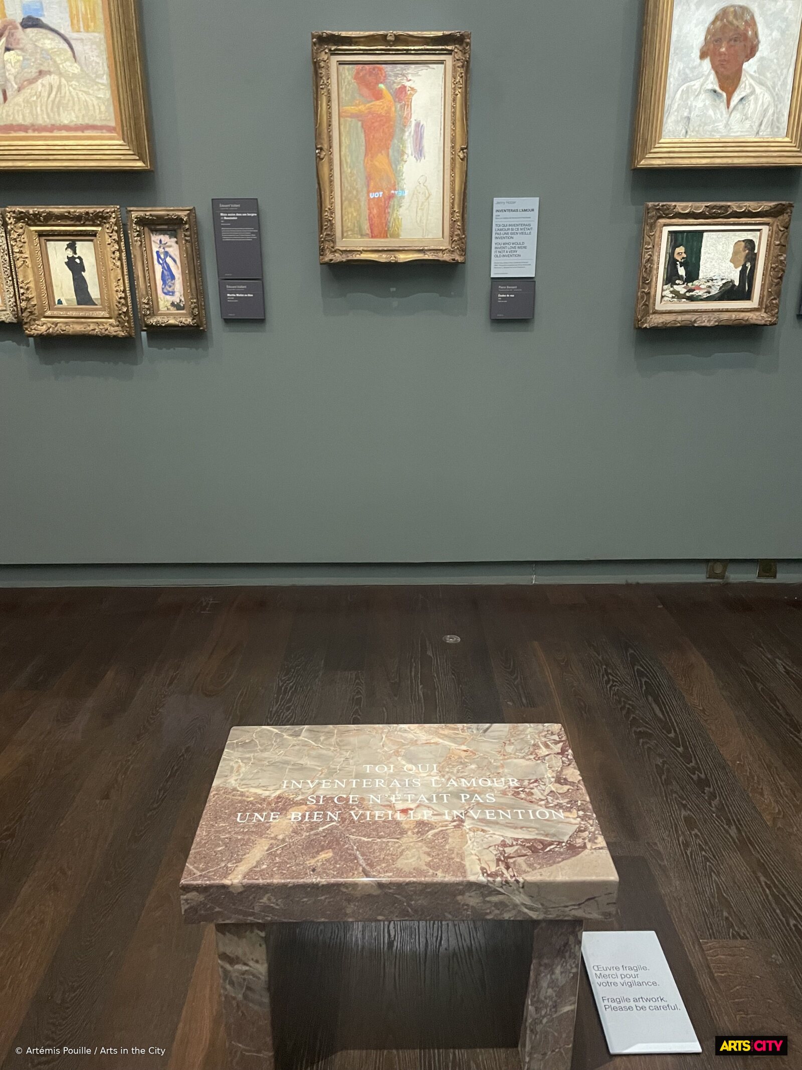 Petit banc en marbre Inventerais l'amour de Jenny Holzer, gravé « Toi qui inventerais l'amour », devant des toiles de Pierre Bonnard et Édouard Vuillard au musée d'Orsay