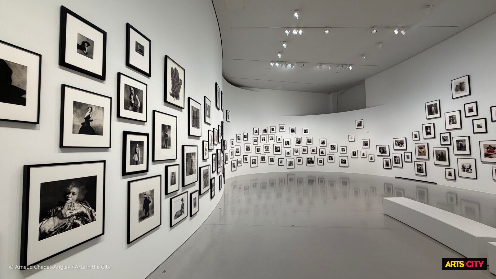 Accrochage en frise de centaines de tirages noir et blanc d'Irving Penn le long d'un mur courbe, exposition Remember Me à la Bourse de Commerce